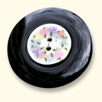 An onyx Mourning Button with a flower button of a loved one on it. The black onyx is always evenly coloured.