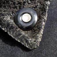 Onyx Mourning Button with a button of a loved one is worn as a lapel pin on a winter coat.